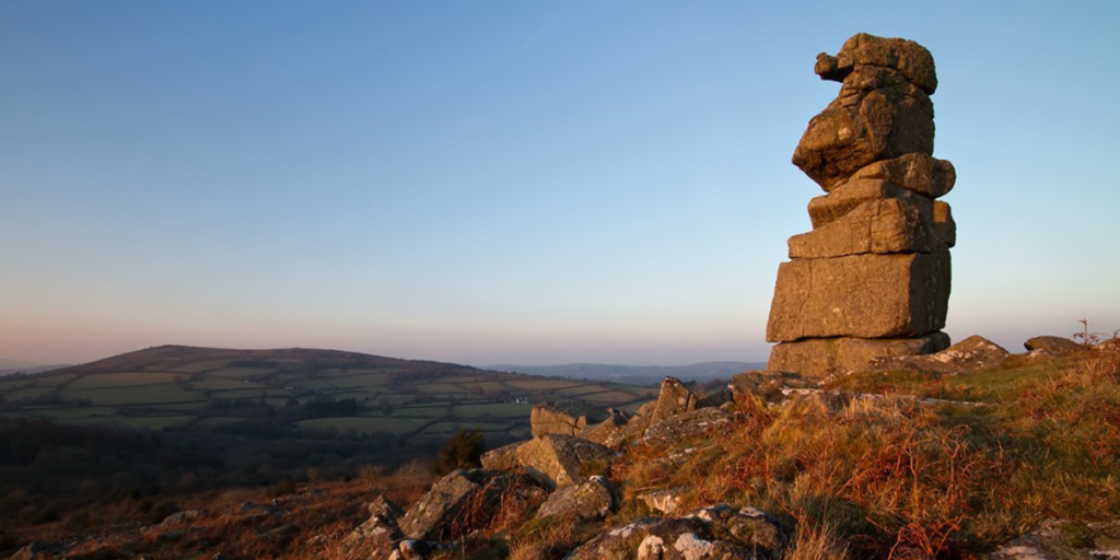Rock feature on dartmoor with views behind of the rugged moorland