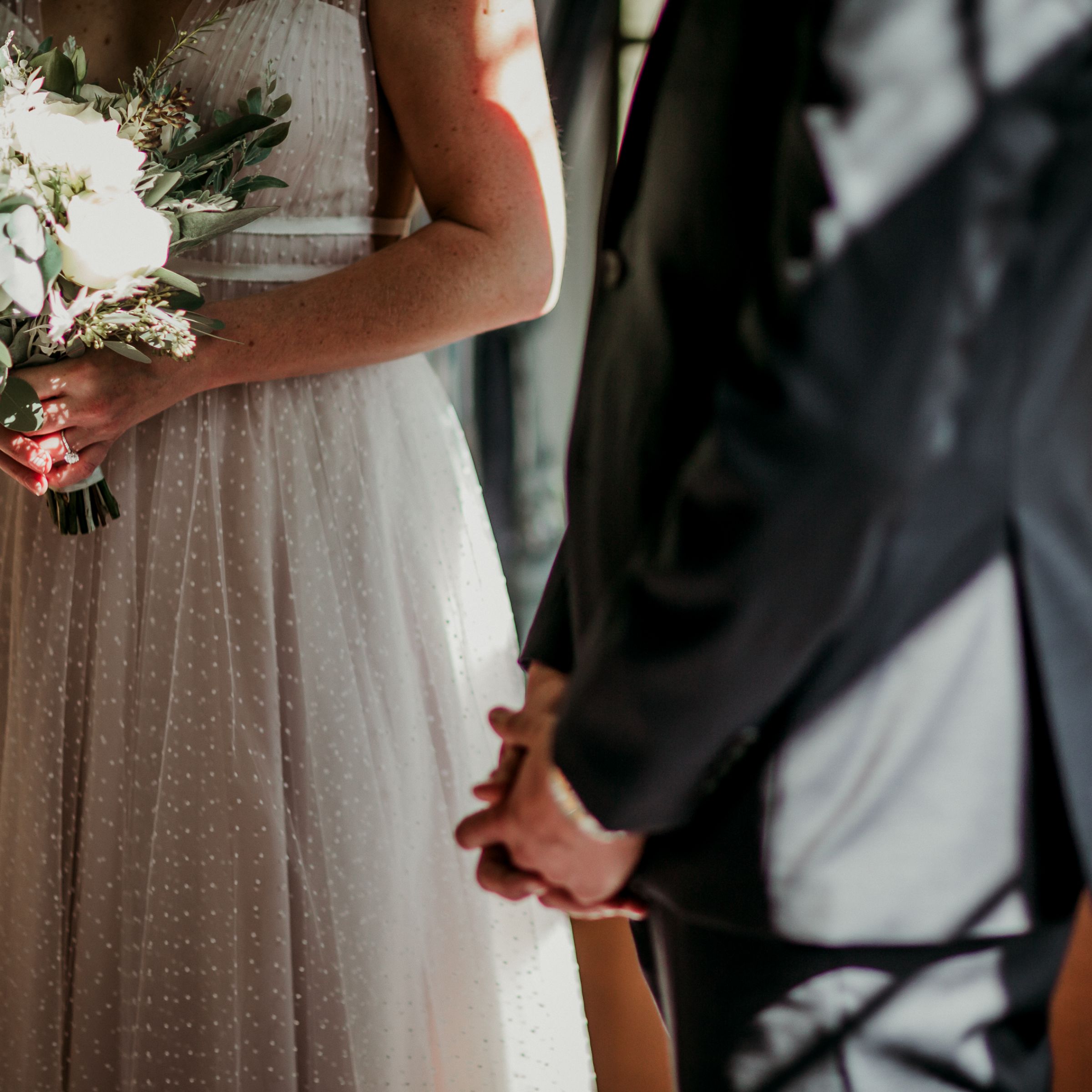 Bodyshots of bride in wedding dress and groom in suit 