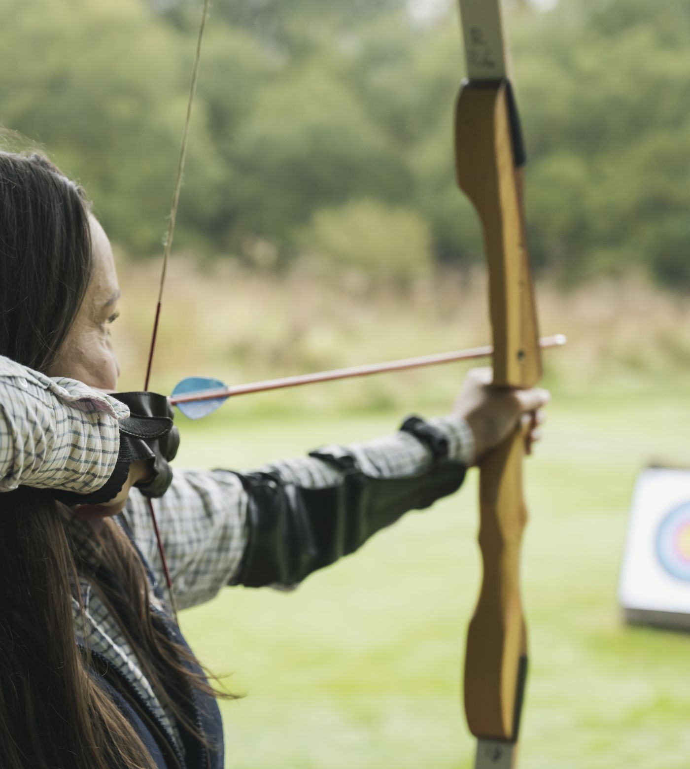woman taking aim with bow and arrow 