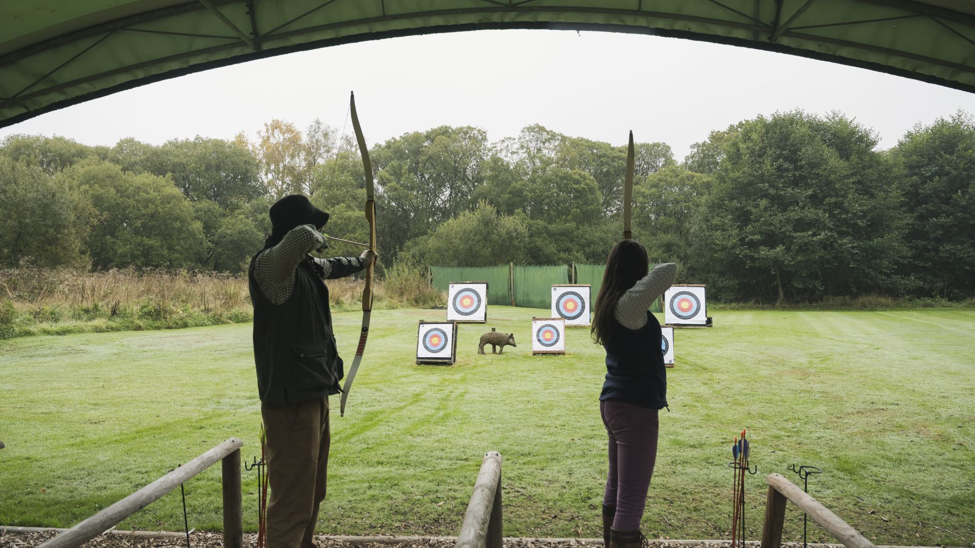 Couple taking aim with bow and arrows